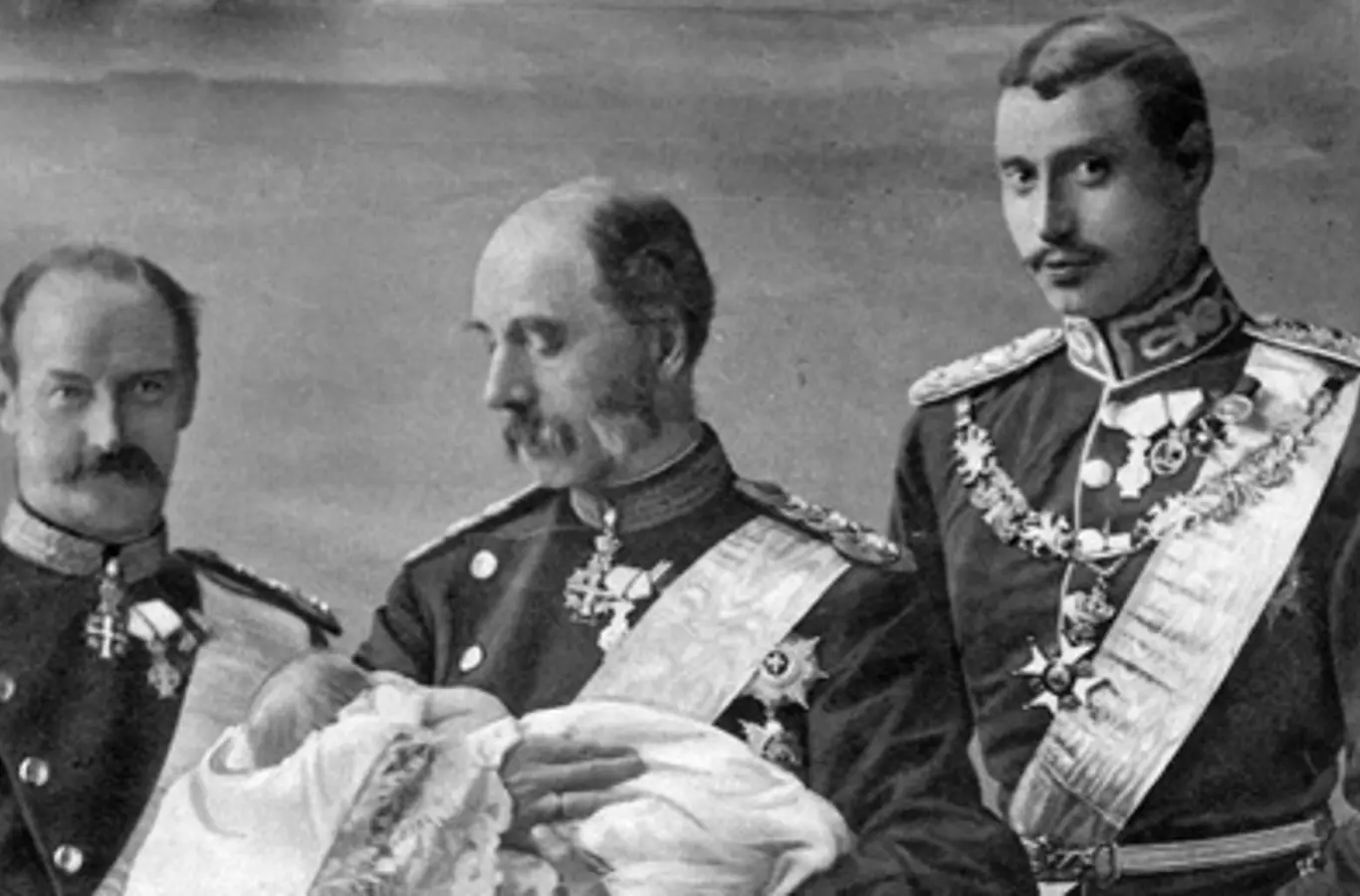 På billedet ses i midten Christian 9. med Frederik 9. i armene. Til venstre Frederik 8. og til højre Christian 10.